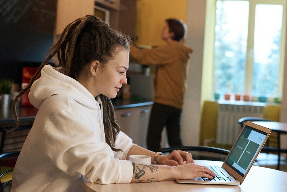A woman working at a laptop in home surroundings. A woman working at a laptop in home surroundings.