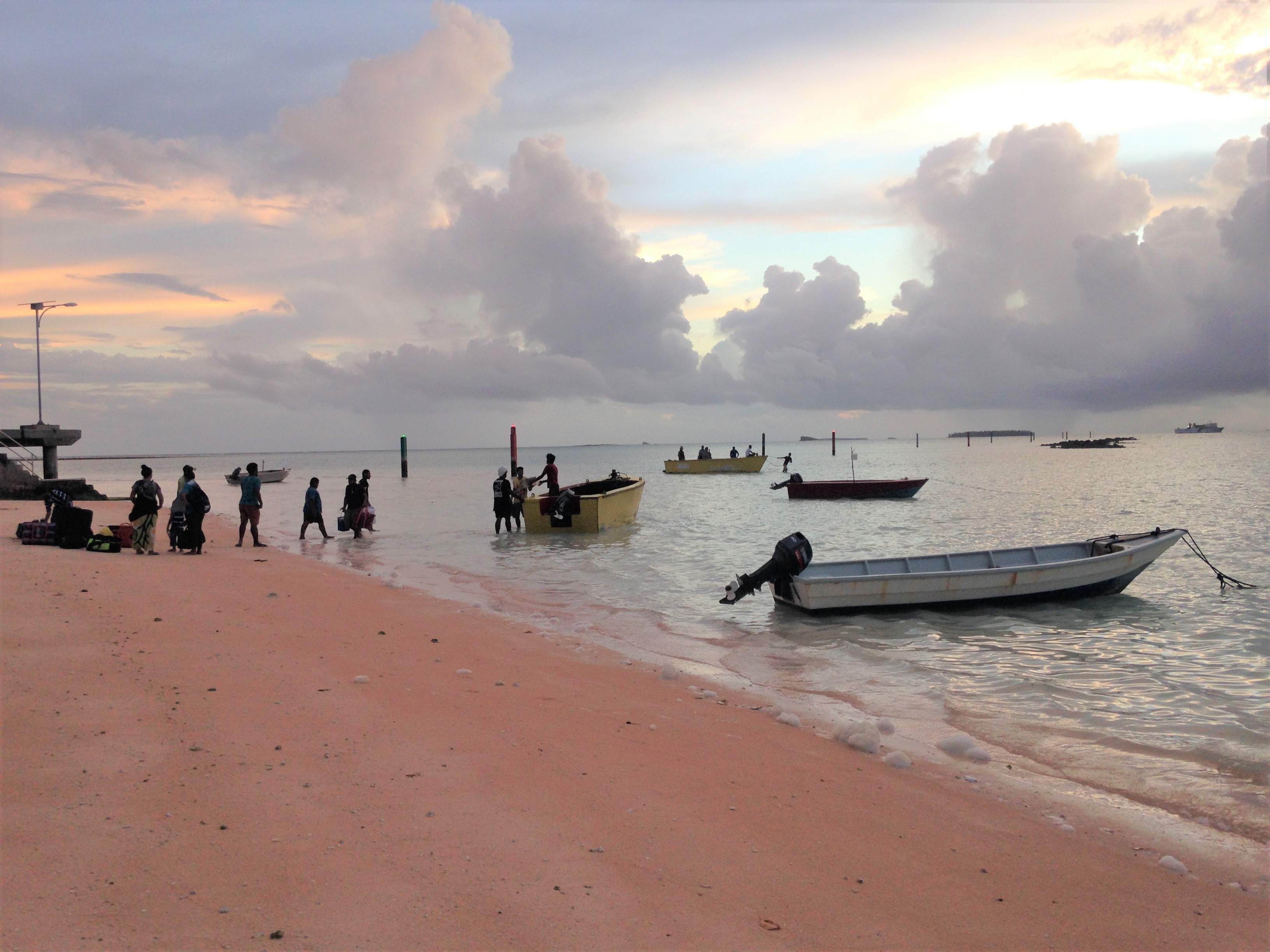 Coastline of Tuvalu showing residents with boats on the shore