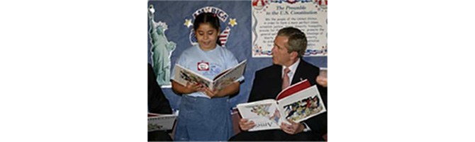 President George W. Bush with a childs book upside down