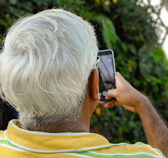 An older man looks at a smartphone