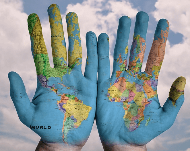 Two hands with a global map painted on it