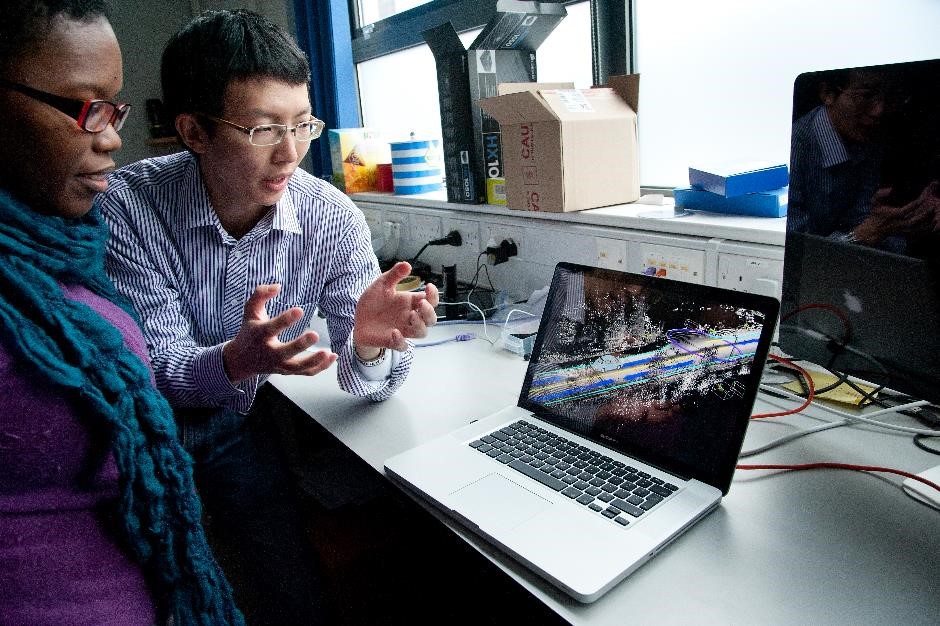 Oxford University researchers discussing images on a laptop. 